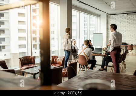 young caucasian business leaders gathered in office for coworking, hold meeting for discussion and having effective cooperation, everyone dressed in f Stock Photo