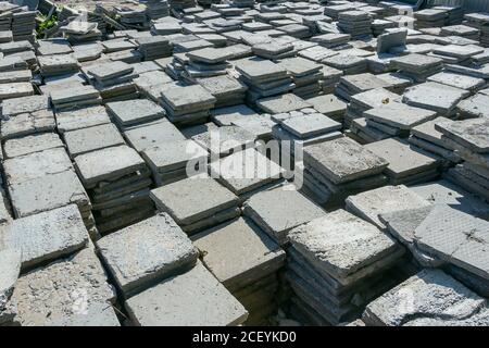 Old paving slabs stacked. Repair work on the road. Reconstruction of the footpath. Road surface material Stock Photo