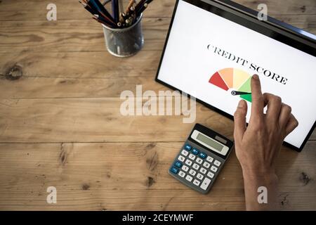 online finances hand pressing credit score button on tablet Stock Photo