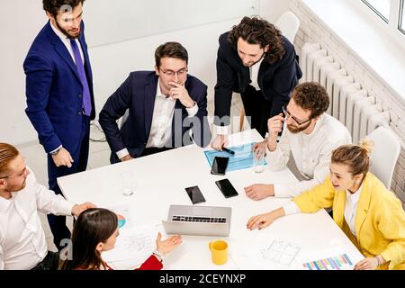 top view on active discussion, business co-working of young diverse business partners and colleagues, enthusiastically working in office together Stock Photo