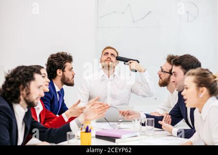 young caucasian man want to get rid of problems at work, business man have trouble, depressed and unhappy male feel bad among swearing colleagues. Stock Photo