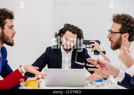 young business people gathered to discuss conflict, problem or troube at work. tired boss businessmen feel negative emotions and want to commit suicid Stock Photo