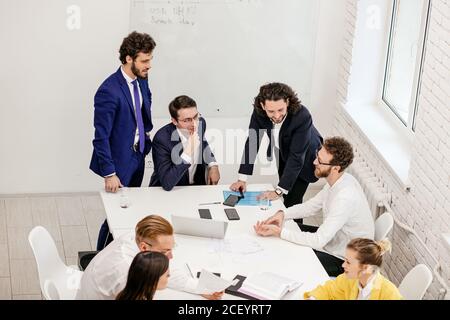 top view on business meeting of caucasian young people, successful team gathered in office, professional managers in formal wear. Business people conc Stock Photo