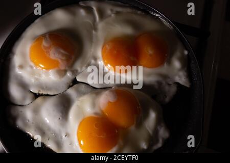 Scrambled eggs made from three eggs, two of which with two yolks in a skillet. Stock Photo