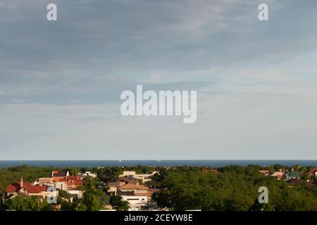 Coastal village with red roofs. Sea and storm clouds in the background. Stock Photo