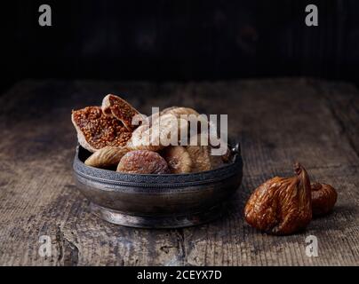 bowl of dried figs on old rustic wooden table Stock Photo