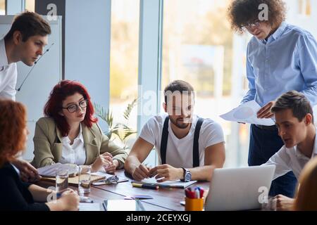 creative and enthusiastic business group sitting in office together working as team, wearing formal wear. Caucasian business people Stock Photo