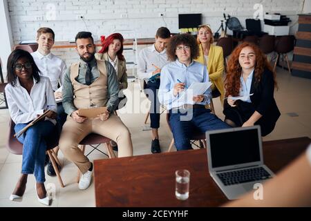 business team sitting and listening to business coach on training, trainer, discussing business strategy, plans Stock Photo
