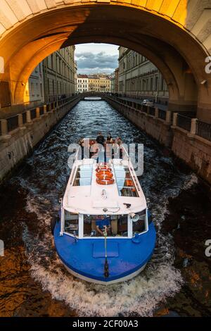 Touristic boat with passengers during the excursion in Winter Canal in St. Petersburg near the Hermitage on autumn evening at sunset. View from above Stock Photo