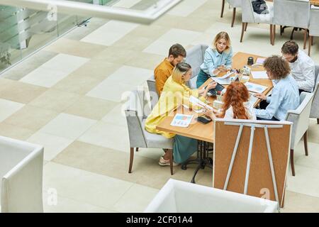 Pretty talented interior designers sharing ideas while having meeting in cozy boardroom, teamwork concept, tot right side shot Stock Photo