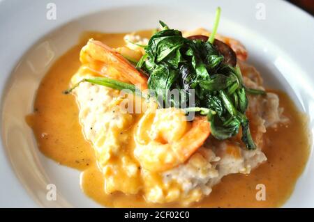 Shrimp and Grits with sauteed spinach Stock Photo
