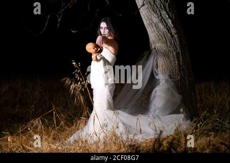 Horror Scene of a Woman Possessed holding a doll. High quality photo Stock Photo