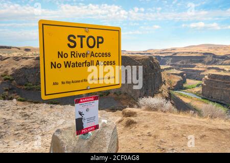 A warning sign on the trail above the Palouse Falls canyon state park warning hikers of danger and deaths. Stock Photo