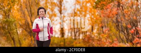 Autumn running middle age woman jogging banner Stock Photo