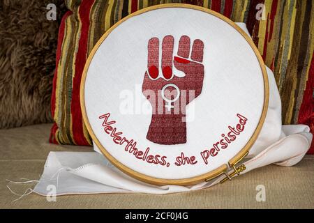 Nevertheless she persisted text with raised fist embroidery on hoop, craftivism feminist activism. Stock Photo