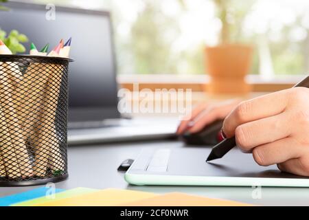 Beautiful graphic designer drawing digital design on a drawing tablet Stock Photo