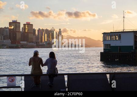 Women sitting next to Star Ferry Pier, Tsim Sha Tsui, Kowloon, Hong Kong Stock Photo