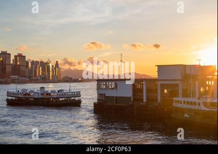 Star Ferry approaching Star Ferry Pier at sunset, Tsim Sha Tsui, Kowloon, Hong Kong Stock Photo