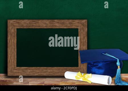 Education concept of graduation hat and diploma on wooden classroom table with copy space on blank photo frame for text. Stock Photo