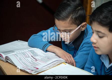 Jodhpur, Rajasthan, India - Jan 10th 2020: Primary indian students studying in the Classroom Taking Exam / Test Writing in Notebooks. education concep Stock Photo