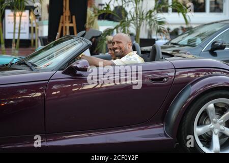 MIAMI BEACH, FL - APRIL 25: (EXCLUSIVE COVERAGE) Israli super-model Bar Paly and Dwayne 'The Rock' Johnson film a scene together in a purple Chrysler Prowler, on the set of Pain and Gain which is directed by Michael Bay. Pain and Gain is about a pair of bodybuilders in Florida get caught up in an extortion ring and a kidnapping scheme that goes terribly wrong. on April 25, 2012 in Miami Beach, Florida. ( Credit: Storms Media Group/Alamy Live News Stock Photo