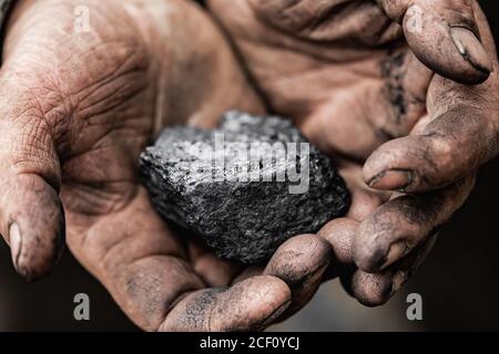 Closeup Miner holds coal palm. Concept mining, Top view Stock Photo