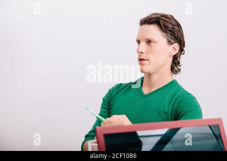 Close-up of office worker sitting with green jersey Stock Photo