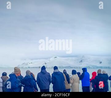 a group of people watching glacier in Antarctica Stock Photo
