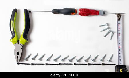 Building tools pliers, self-cutters, screwdrivers and measuring roulette on a white background with space for text. Repairs and construction. Stock Photo
