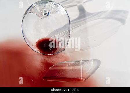 Broken wine glass with red wine. Glass of wine, broken on the mirror. Isolated on white. Stock Photo