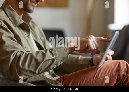 Close-up of man typing on digital tablet and working online at office Stock Photo