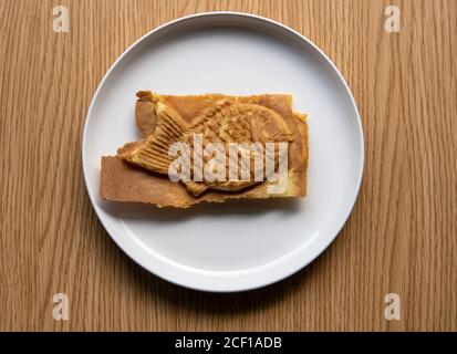 Taiyaki is a Japanese filled pastry. Battered waffle like fish shaped sweet snack food treat generally filled with bean paste, custard,or sweet potato Stock Photo