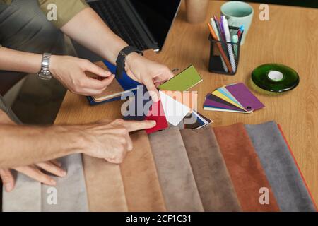 Close-up of fashion designers examining the samples and choosing the suitable color of fabric at office Stock Photo