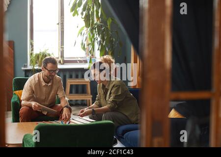 Two business partners sitting on sofa and working at the table in team at modern office Stock Photo