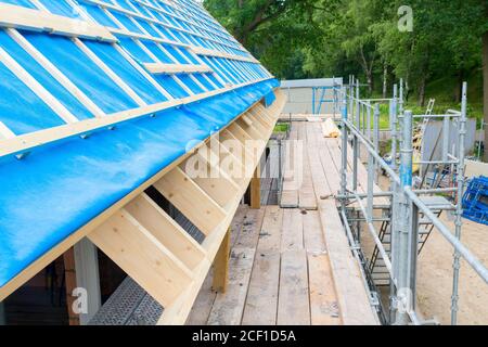 Wooden scaffolding next to roof of new home on construction site Stock Photo
