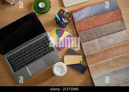 High angle view of workplace of designer with laptop and fabric samples Stock Photo