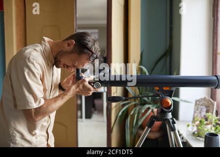 Young man looking through the telescope he watching for stars and planets Stock Photo