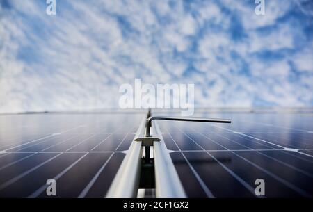 New solar module with beautiful blue sky on blurred background. Solar power system for generating electricity through the photovoltaic effect. Concept of alternative energy, ecological solution