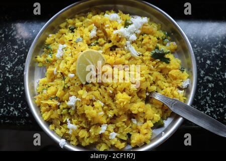 Kanda Poha popular Maharashtrian breakfast recipe made from red or white flattened rice, potatoes, onions, herbs and spices Stock Photo