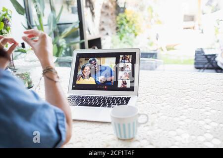 Woman video chatting with friends on laptop screen Stock Photo