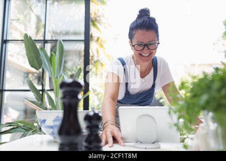 Smiling woman using digital tablet at dining table