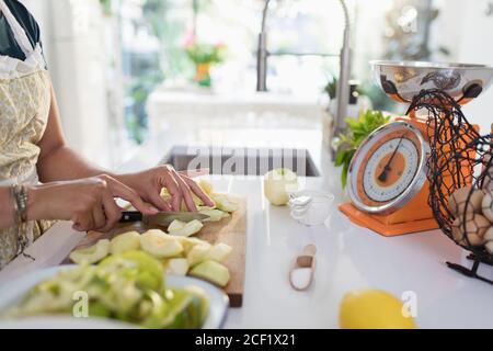 Woman slicing apples for baking in kitchen Stock Photo