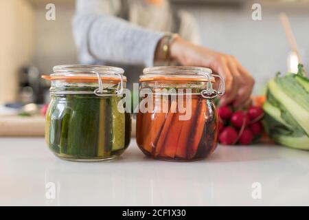 Close up woman pickling vegetables in jars Stock Photo