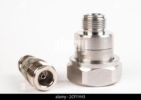 Microwave coaxial adapter 7 16 DIN Male To N Female connector. Concept of radio details. High frequency component with a metallic covering on white ba Stock Photo