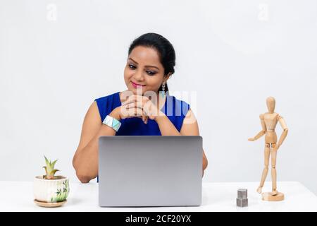 Pretty Indian woman at the table,  Freelancer, distant work, work at home, online education, Office work at home, smiling, happy and excited. Stock Photo