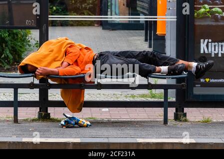 A drunk man sleeps in a tram station, a homeless man sleeps in a tram station Stock Photo