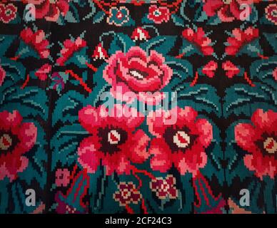 Moldavian national woven carpet, traditional floral pattern. Handcrafted vintage style rug, cultural symbol of Moldova and Romania folklore. Red flowe Stock Photo