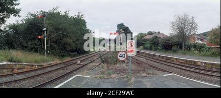 Helsby, UK - 21 July 2020: The speed limit sign, notices and semaphore signals at the end of the platform. Stock Photo