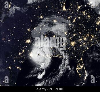 Storm Laura over USA at night, tropical hurricane eye from space. Typhoon landfall and city lights of Earth on satellite photo. Weather and warning co Stock Photo