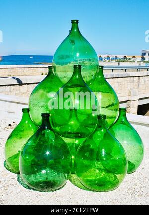 Pyramid set of vintage green glass large bottles demijohns for wine, vertical Stock Photo
